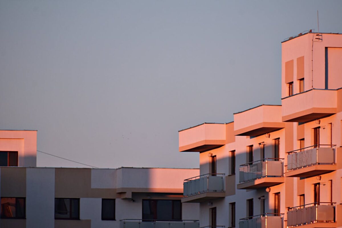 Offres Modern apartment building with balconies bathed in sunset light.