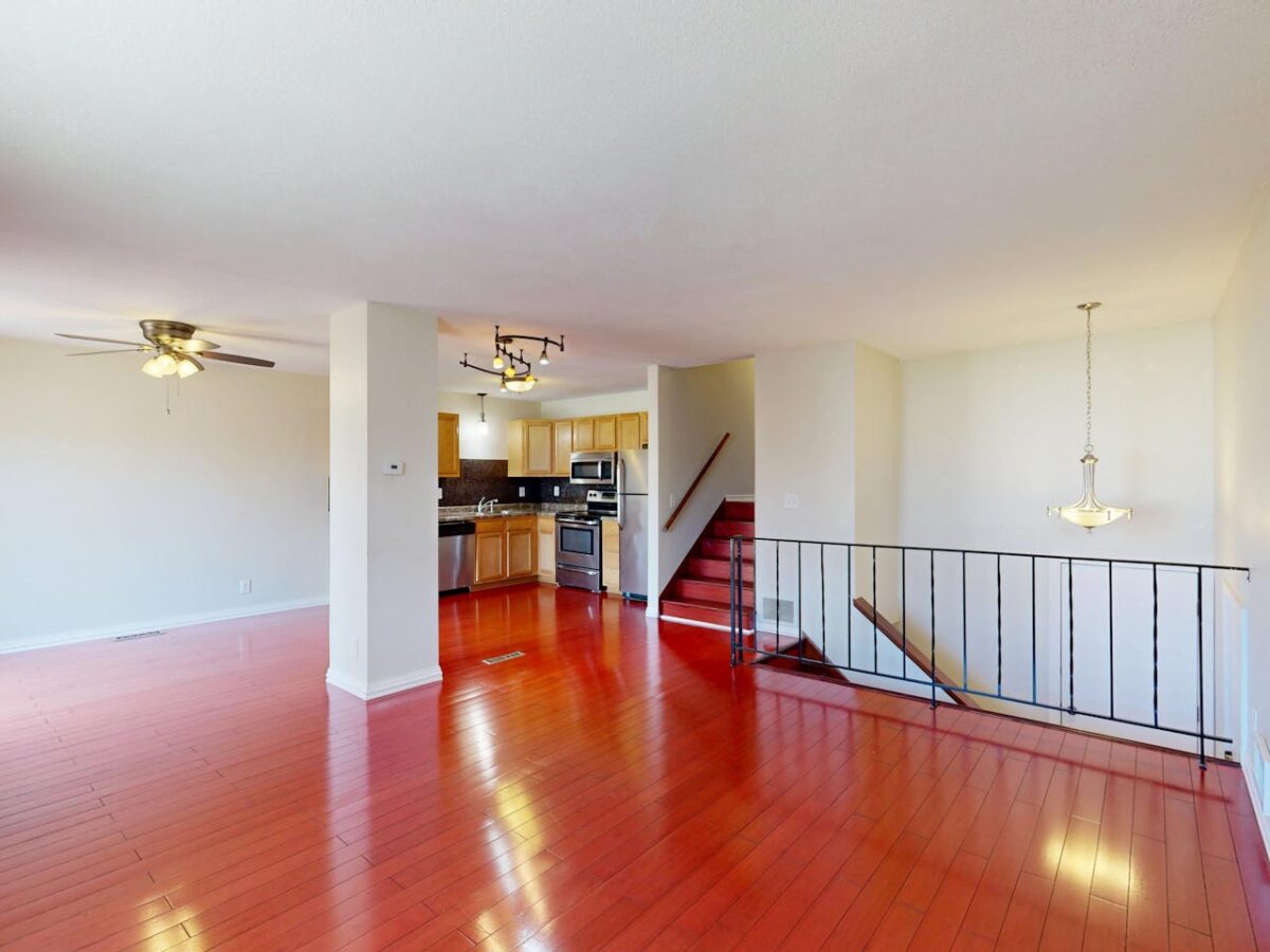 Offres Modern open-concept kitchen with hardwood floors and natural lighting.