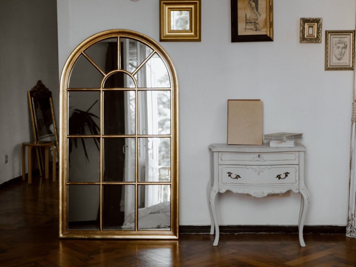 Huardière Vintage-style interior featuring a gold arched mirror and a classic white console table.